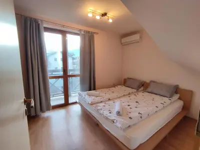 a bedroom with a bed and a large window at Pirin Sunrise in Bansko
