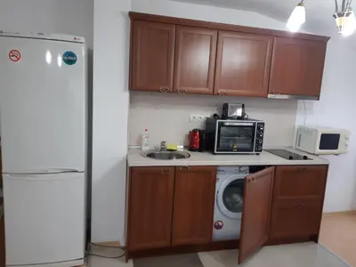 a kitchen with a microwave and a washing machine at Gondola lift apartment in Bansko