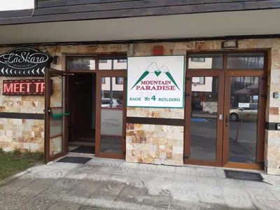 an entrance to a restaurant with a sign on the door at Gondola lift apartment in Bansko