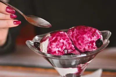 a person holding a spoon with a scoop of ice cream at Хотел Феникс in Chepelare