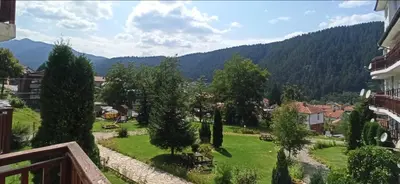 a view from a balcony of a town with trees and mountains at Апартамент Bella Casa in Beli Iskar