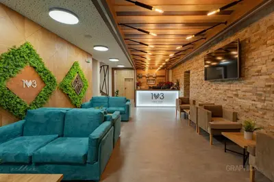 a waiting room with blue couches and chairs at 103 View Park Hotel in Panichishte