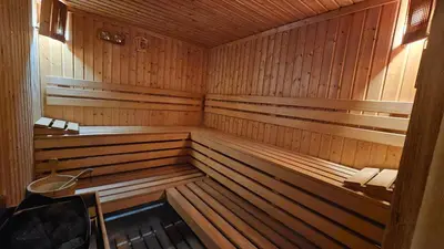 a sauna with wood paneling and a bench in it at Апартамент Edelweiss in Beli Iskar