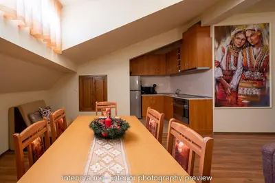 a dining room with a table and a kitchen with a painting at MOMA - Charming home in the heart of Bansko Ancient Center in Bansko