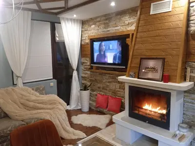a living room with a fireplace and a tv at Mila VIP Apartment in Bansko
