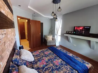 a bedroom with a bed with a blue comforter at Mila VIP Apartment in Bansko