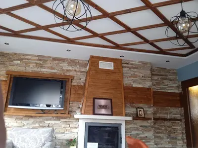 a living room with a stone wall with a tv and a fireplace at Mila VIP Apartment in Bansko