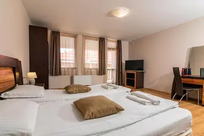 two large white beds in a room with a desk at АПАРТАМЕНТ ЗА ГОСТИ ЕВЕЛИН in Pamporovo