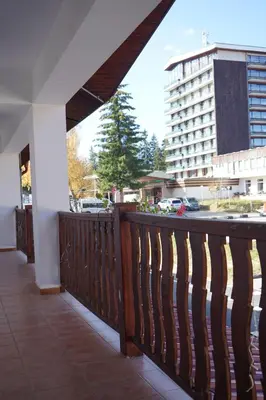 a balcony with a wooden fence and a building at АПАРТАМЕНТ ЗА ГОСТИ ЕВЕЛИН in Pamporovo