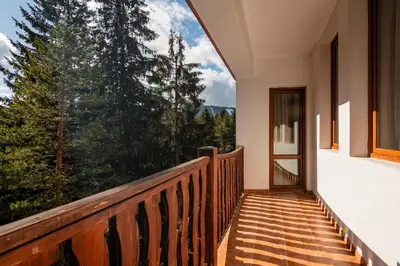 a balcony of a house with a large window at АПАРТАМЕНТ ЗА ГОСТИ ЕВЕЛИН in Pamporovo