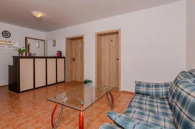 a living room with a couch and a glass table at АПАРТАМЕНТ ЗА ГОСТИ ЕВЕЛИН in Pamporovo