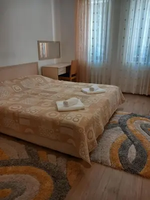 a bedroom with a bed with two towels on it at Апартамент в хотел Стената, Пампорово in Smolyan