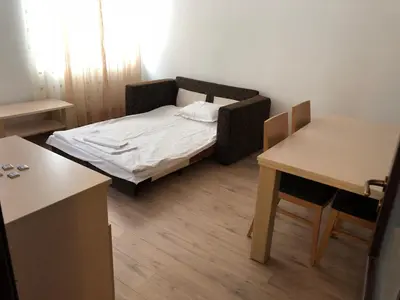 a small room with a bed and two tables at Апартамент в хотел Стената, Пампорово in Smolyan