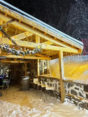 a group of chairs sitting under a building in the snow at Апартамент в хотел Стената, Пампорово in Smolyan