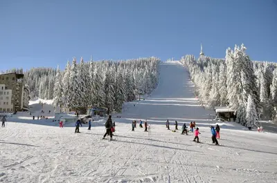 a group of people standing on a snow covered slope at Студио, хотел Стената in Pamporovo