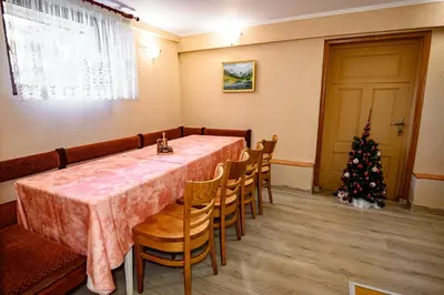 a dining room with a table and a christmas tree at Lalev Guest House in Bansko