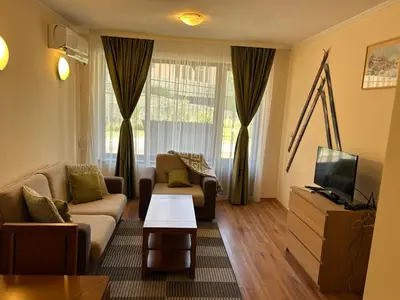 a living room with a couch and a tv at Charming apartmnet near Gondola and Bar street in Bansko