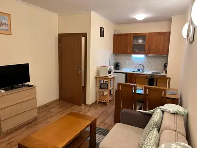 a living room with a couch and a kitchen at Charming apartmnet near Gondola and Bar street in Bansko