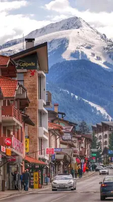 a street in a town with a snow covered mountain at Belvedere Holiday Club h 305 in Bansko