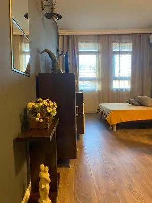 a bedroom with a bed and a table with flowers at Studio Nr 6 in Bansko