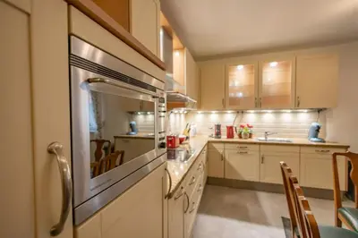 a large kitchen with white cabinets and a sink at Зеления Осъм Green Osam in Chiflik