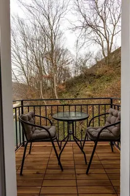 a patio with a table and two chairs on a balcony at Зеления Осъм Green Osam in Chiflik