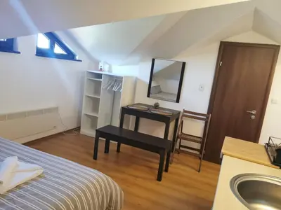 a bedroom with a sink and a table with a mirror at Pirin and Bansko view Studio in Bansko