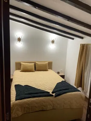 a bedroom with a bed with two lights on the wall at Villa Elias in Zlatograd