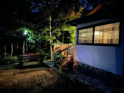 a wooden bench next to a building with a window at Villa Elias in Zlatograd