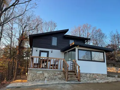 a small black and white house with a porch at Villa Elias in Zlatograd