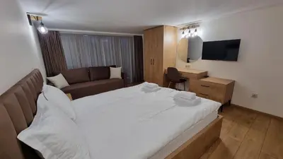 a bedroom with a large white bed and a couch at Guest House Gogemi in Bansko