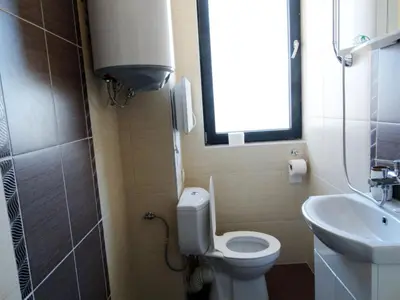 a small bathroom with a toilet and a sink at Apartments EMIZA in Samokov