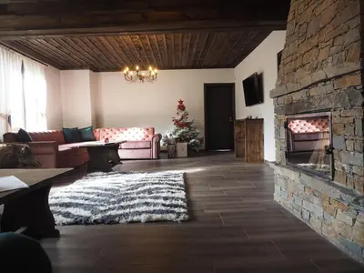 a living room with a couch and a fireplace at Vladimirov's House Kovachevitsa , Цяла къща in Kovachevitsa