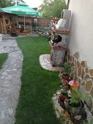 a backyard with a grill and green grass at Petar Guest House in Bansko