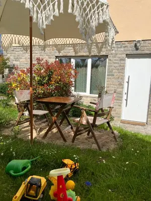 a picnic table and chairs under an umbrella in the grass at Lavender Suite in Dragichevo