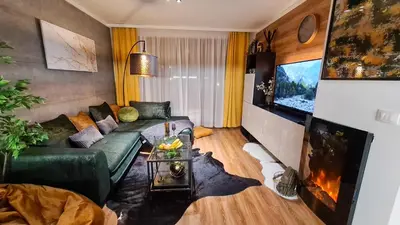 a living room with a green couch and a tv at Apartmanica Double room apartment 101-12, with AC, big terrace, St Ivan Rilski 4 star SPA Resort, Bansko in Bansko