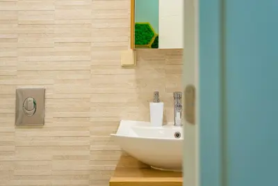 a bathroom with a sink and a mirror at Elite Business Residence with Free Gym Pass, Street Parking and Full Office Setup in Plovdiv