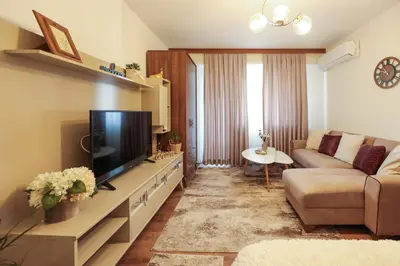 a living room with a couch and a flat screen tv at Central Apartment near the Park in Gotse Delchev