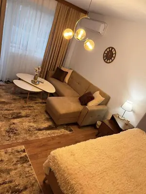 a living room with a couch and a table at Central Apartment near the Park in Gotse Delchev