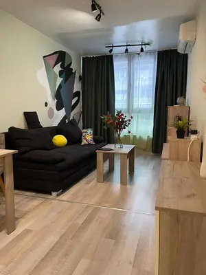 a living room with a black couch and a table at Intelligent Elephant Home - 1BDR Apartment by Flat Mаnager in Sofia