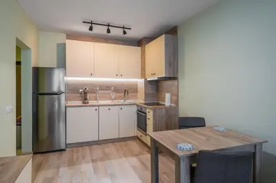 a kitchen with a table and a stainless steel refrigerator at Intelligent Elephant Home - 1BDR Apartment by Flat Mаnager in Sofia