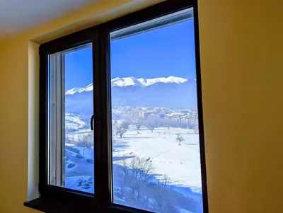 a window with a view of a snowy mountain at Stylish 2BD Apartment with Panoramic Mountain View by Flat Mаnager in Bansko