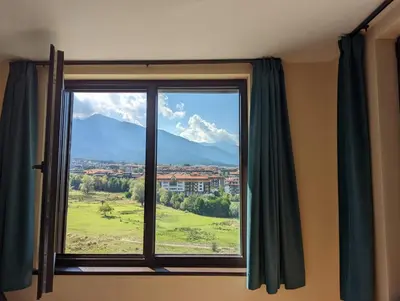 a window with a view of a mountain at Stylish 2BD Apartment with Panoramic Mountain View by Flat Mаnager in Bansko