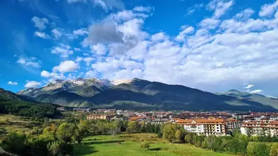 a view of a city with mountains in the background at Stylish 2BD Apartment with Panoramic Mountain View by Flat Mаnager in Bansko