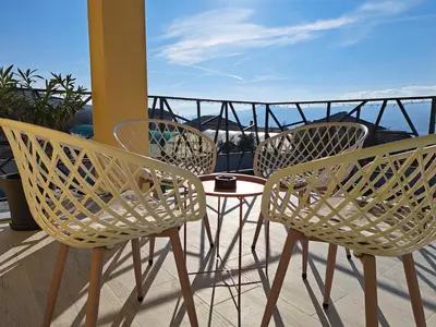 three chairs and a table on a balcony at Sunset view guest house in Ilindentsi