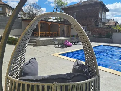 a hammock chair in front of a swimming pool at Sunset view guest house in Ilindentsi