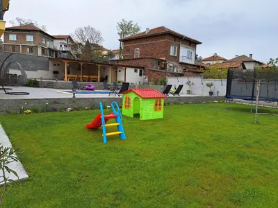 a playground with a slide and a play house at Sunset view guest house in Ilindentsi