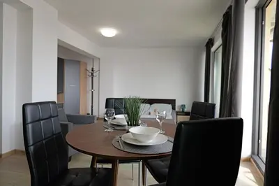 a dining room with a wooden table and black chairs at Panoramic Terrace City View Suite in Sofia Center in Sofia