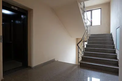 a staircase in a building with a black door at Panoramic Terrace City View Suite in Sofia Center in Sofia