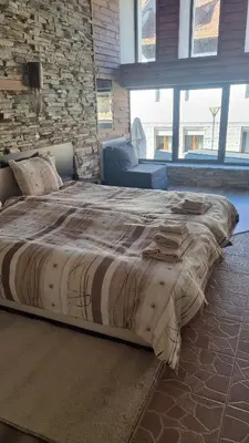 a large bed in a room with a brick wall at Pirin Studios in Bansko